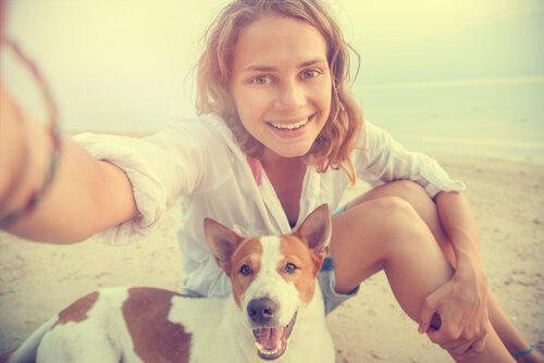 plajda köpeğiyle fotoğraf çeken kadın