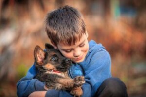 Yavru köpeğe sarılan çocuk